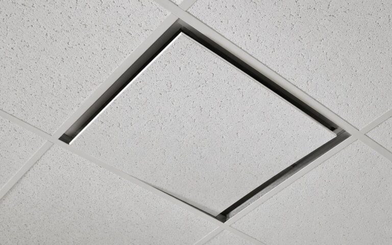 Acoustic ceiling tile being set into the grid