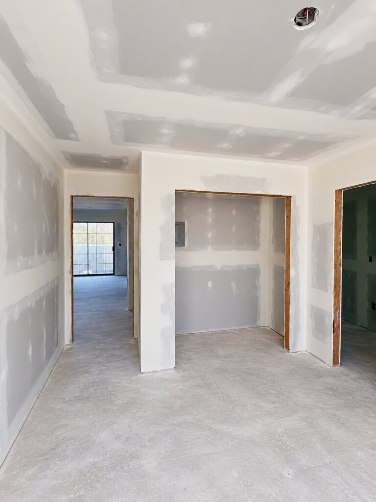 Room with new drywall hung, taped and mudded, ready for finishing