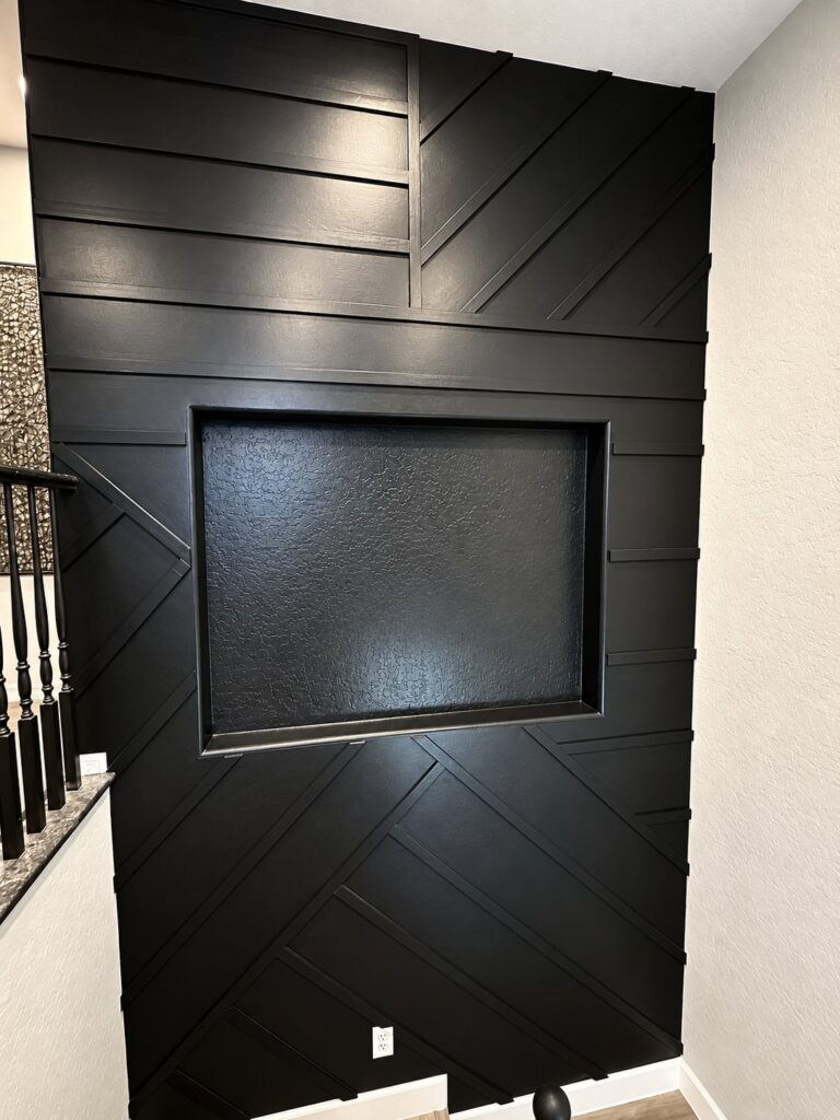 Black geometric batten accent wall with a recessed TV