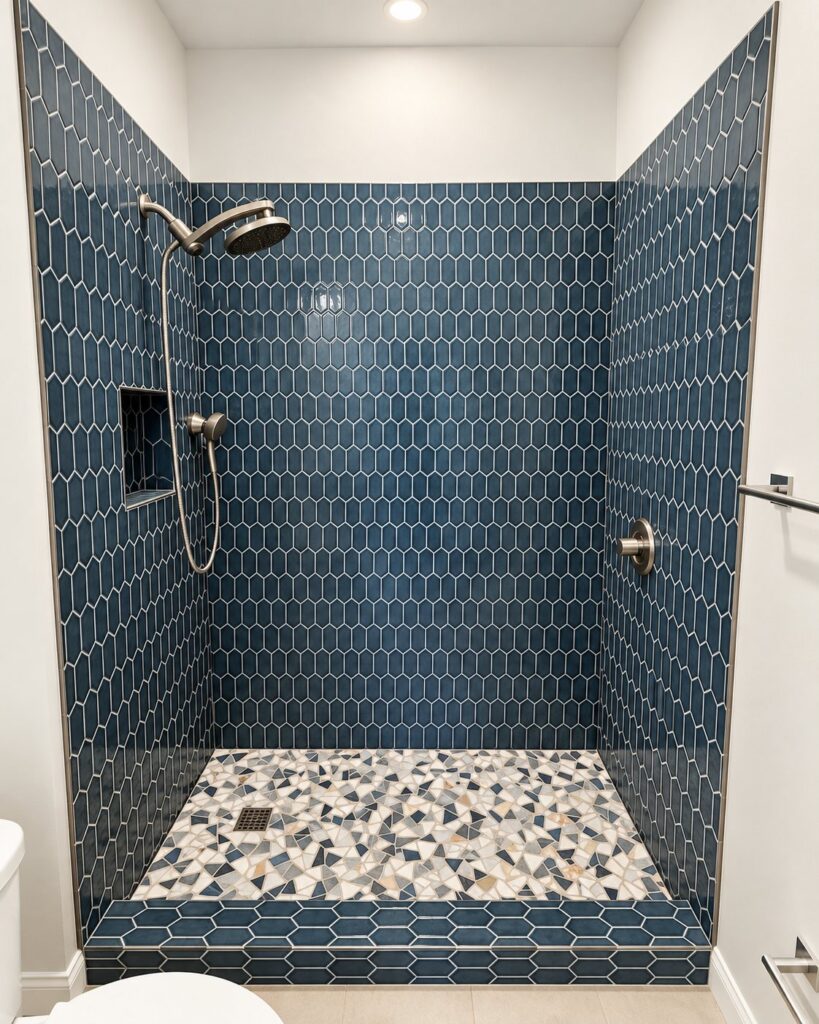 Shower in navy picket tile with a geometric mosaic floor