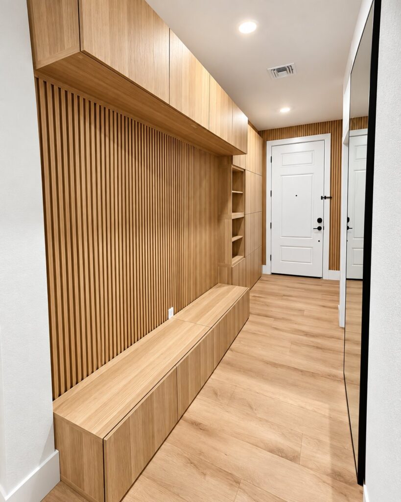 Entry hall with a wood slat wall, bench and built-in storage