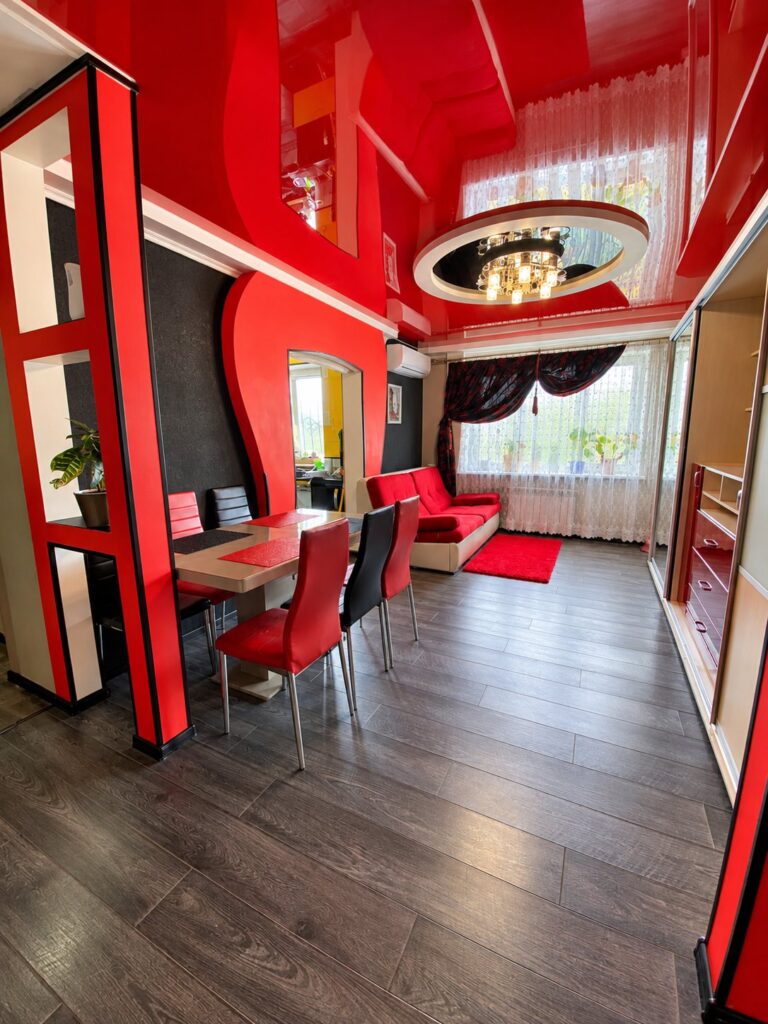 Glossy red stretch ceiling with a round recessed light