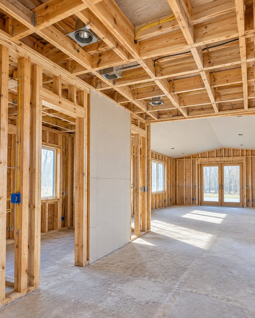 Framed walls and ceiling joists with the first drywall sheet up