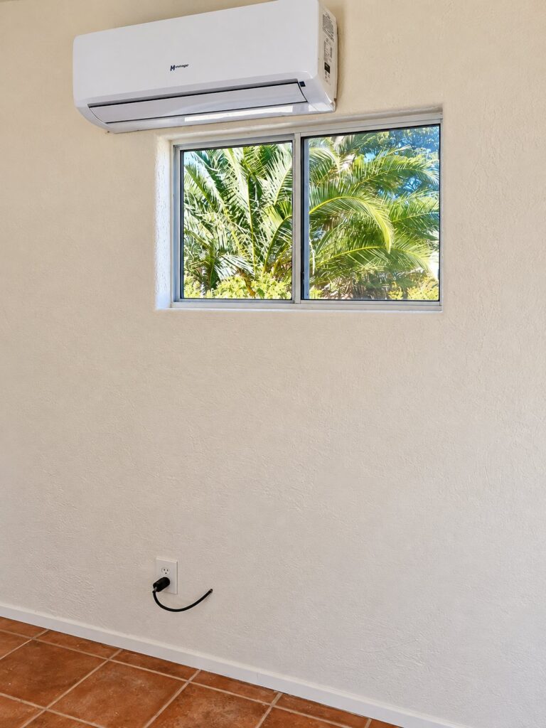 Finished textured wall with a window and a mini-split