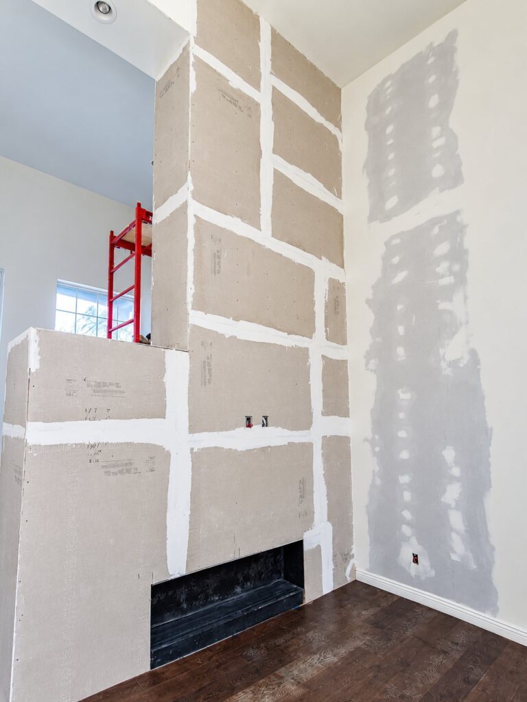 Fireplace wall boarded in drywall with taped seams