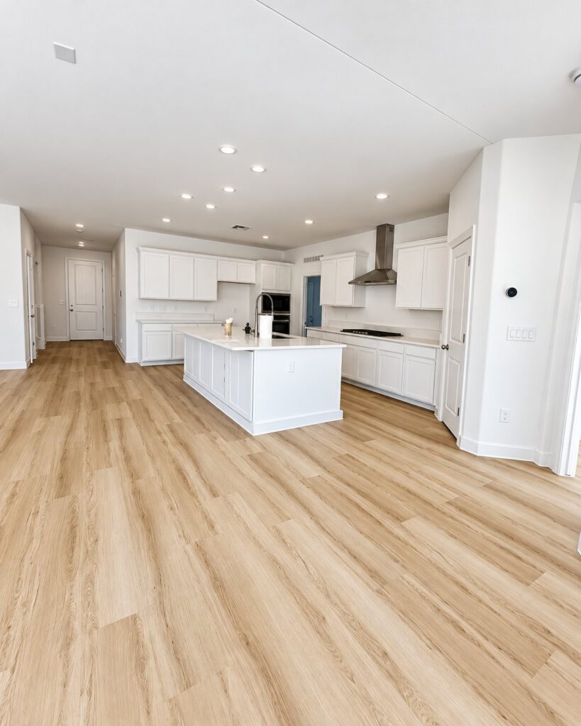 Open kitchen and living area with light oak vinyl plank flooring