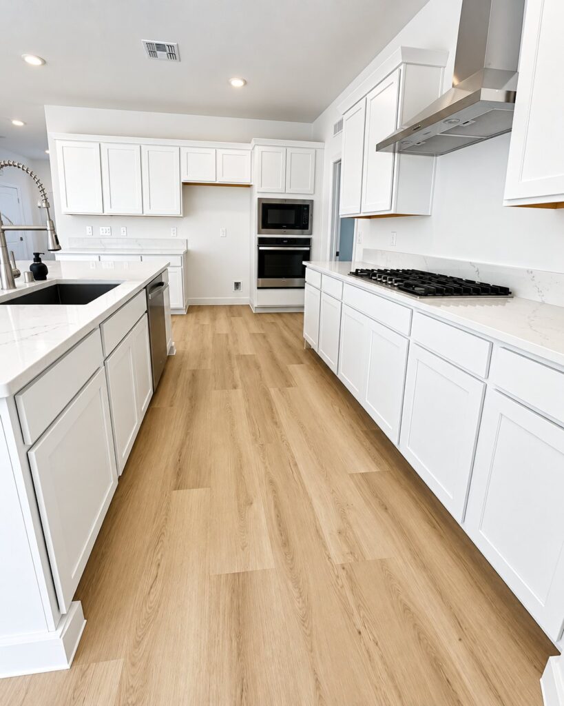 White kitchen with light oak plank flooring