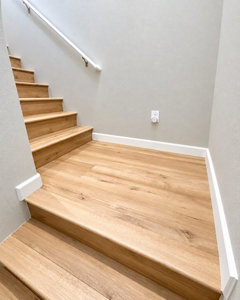 Stair landing with light oak plank treads and new baseboards