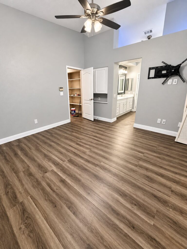 Primary bedroom with gray-brown plank flooring