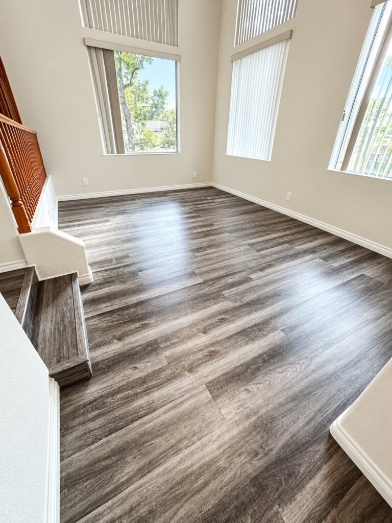 Two-story living room with gray wood-look flooring