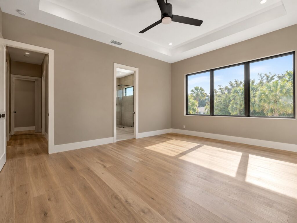 Bedroom with a tray ceiling, oak floors and black-framed windows