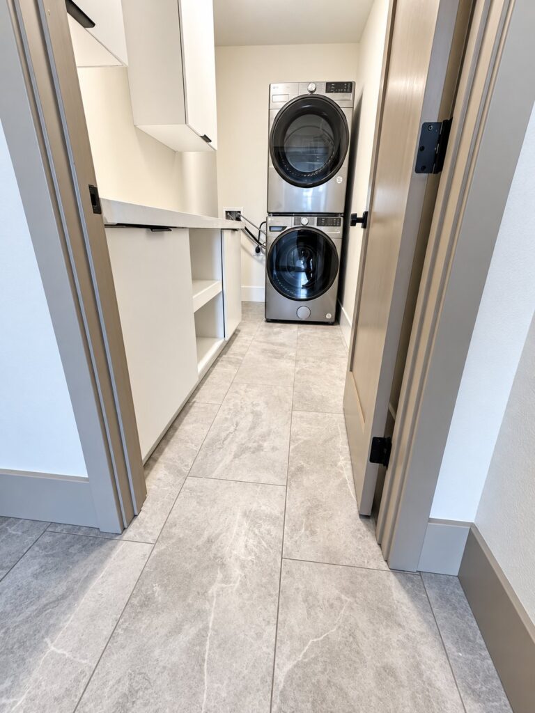 Laundry room with a stacked washer and dryer and built-in shelves