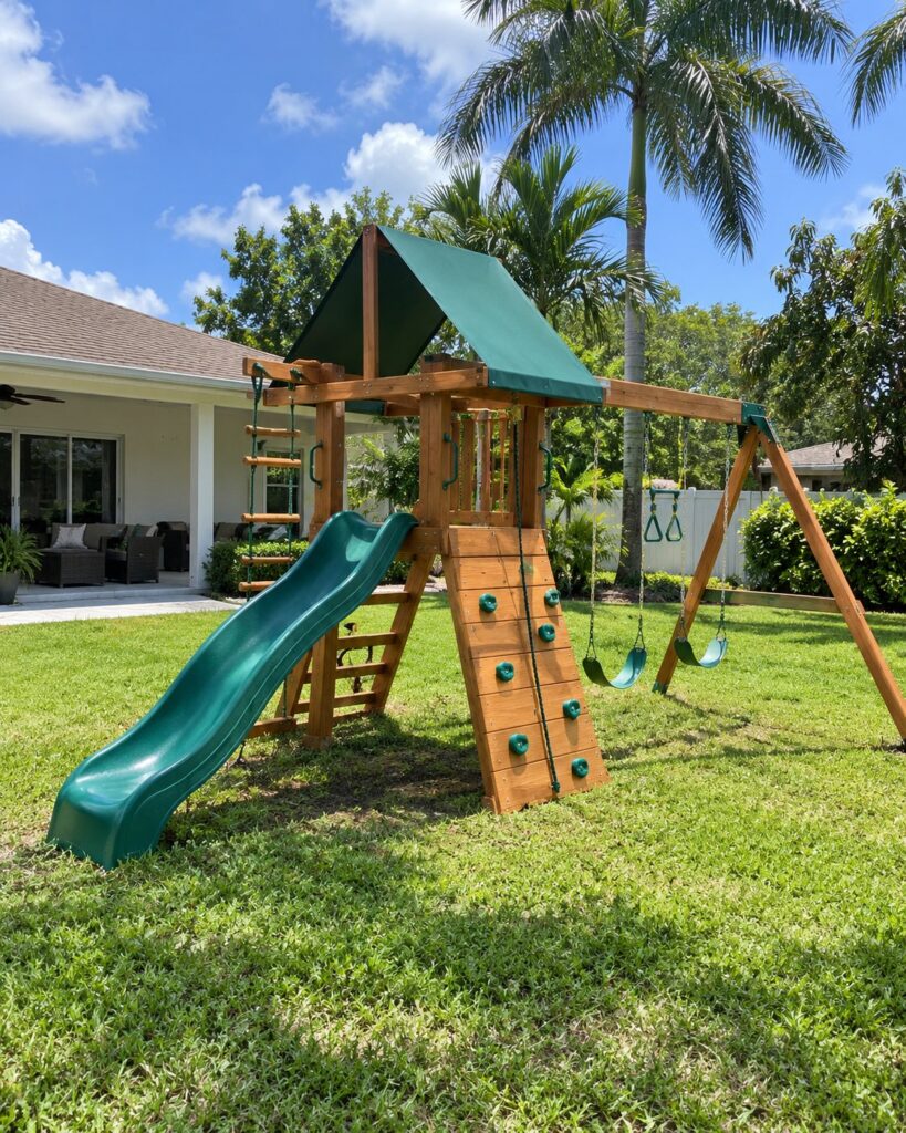 Play set with a green canopy, slide and swings
