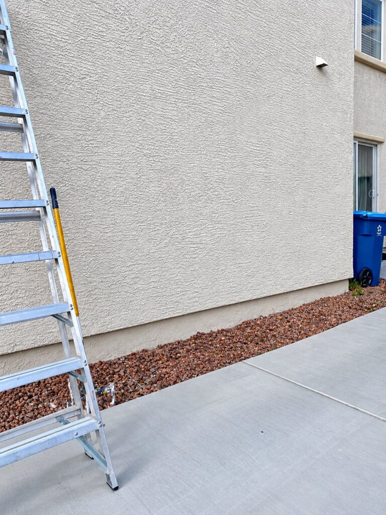 Exterior stucco wall with a ladder during repairs