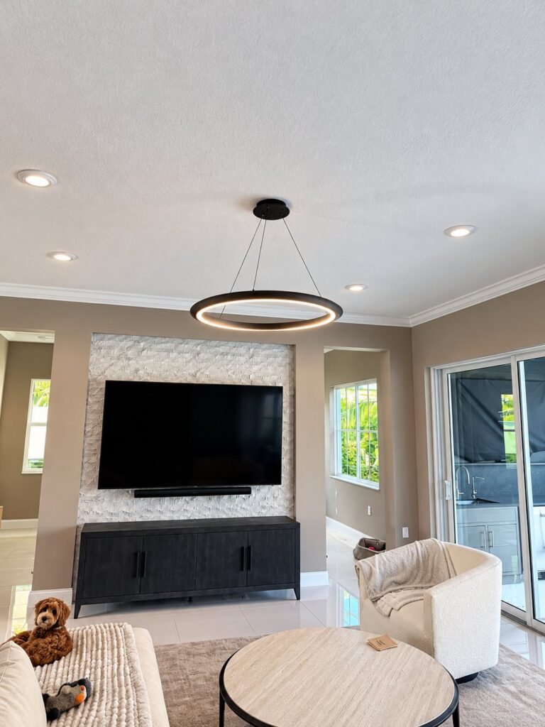 Living room with a ring pendant and a stone TV wall