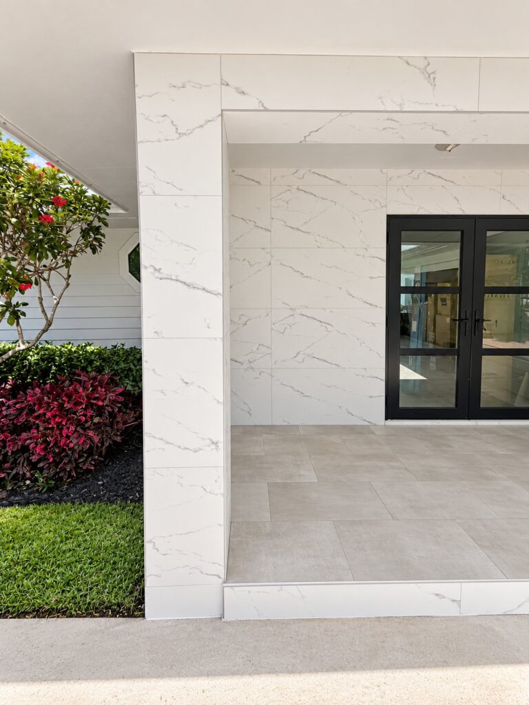 Entry porch with marble-look wall cladding and gray floor tile