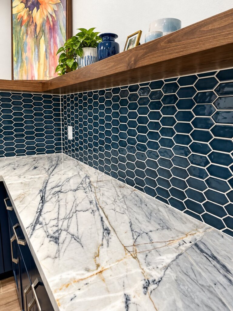 Navy hexagon tile backsplash under a quartzite counter