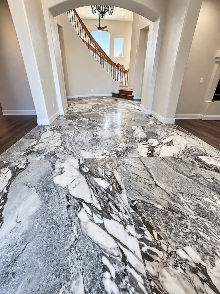 Foyer with polished marble-look floor tile and a curved staircase