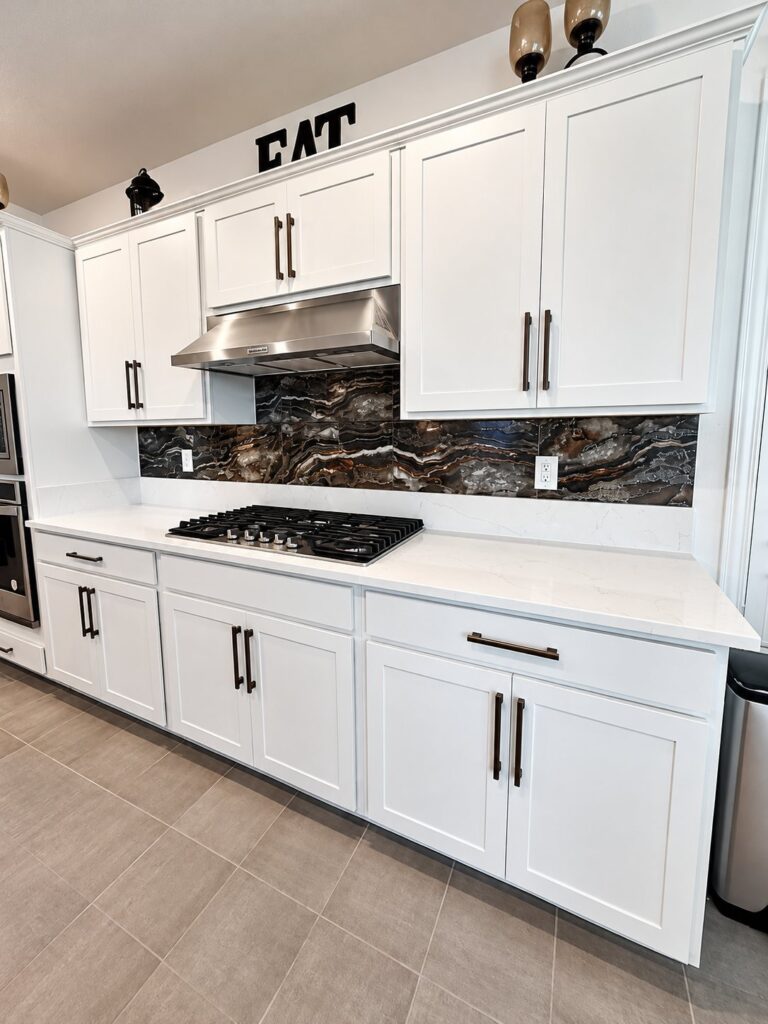 White kitchen with a dark granite slab backsplash