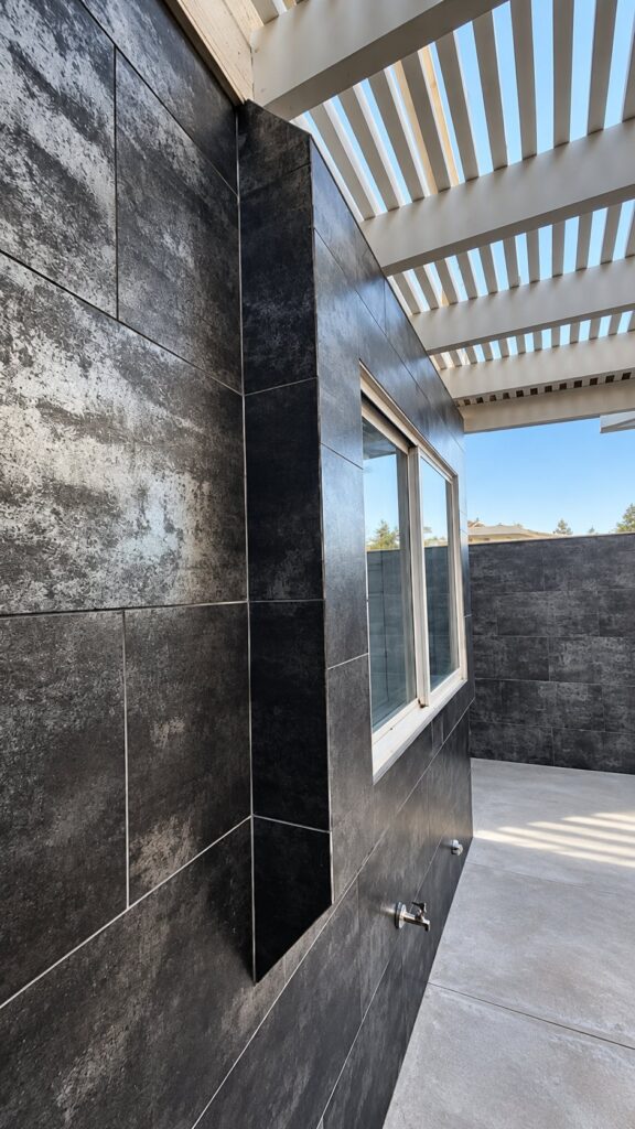 Outdoor shower wall in dark large-format tile