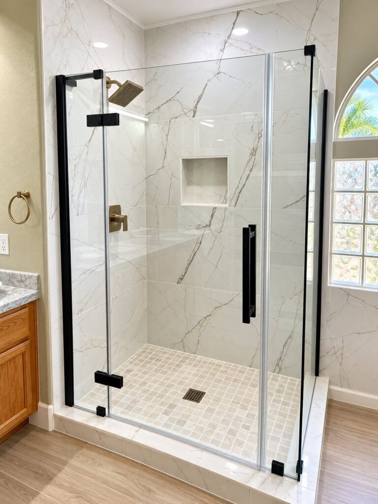 Shower in white marble-look porcelain with a black frameless enclosure