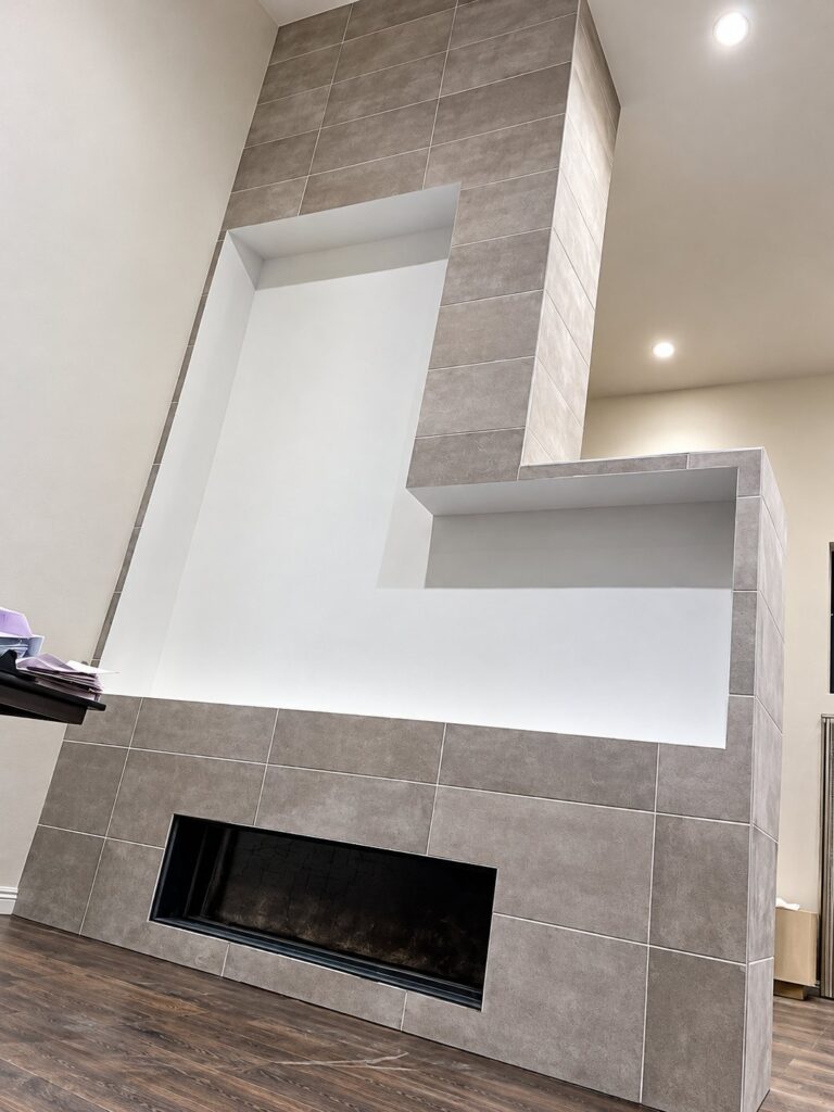 Fireplace surround in large gray tile with a niche
