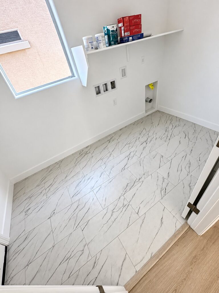 Laundry room with white marble-look floor tile